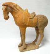 A Chinese pottery model of a standing saddled horse with open mouth on a rectangular base, Tang