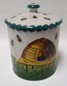 A large Wemyss circular based honey pot and lid, painted with hive and bees in a garden, impressed