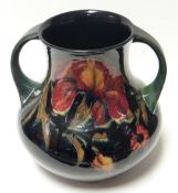 A Moorcroft green and blue ground twin handled vase in the 'Spanish Iris' pattern, signed William