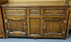 An oak dresser-base having two cupboards and three drawers with brass fittings, circa 1820, 61ins