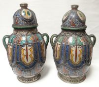A pair of large Persian twin-handled jars and covers, colourfully decorated with multi-colours and