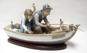 A large Lladro model of an old man, dog and boy apparently catching a fish within a rowing boat,