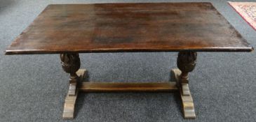 A dark oak refectory style table on carved twin supports and centre stretcher, 60ins long (153cms)