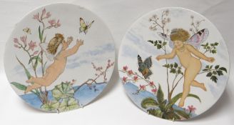 A pair of white painted pottery plaques, naïvely painted with fairies, butterflies and vegetation,