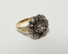 A seven diamond floral ring, the shank of unmarked yellow gold (believed) having split shoulders