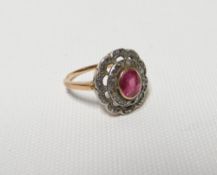 An early twentieth century floral diamond and ruby ring, the shank in unmarked yellow gold (