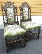 A pair of carved hall chairs with heraldic rails, barley twist supports and stretcher and having