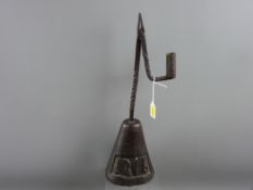 An 18th Century wrought iron rush nip holder on a stained oak base '1716' carved within an open