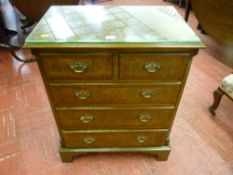 A reproduction walnut chest of two short over three long drawers, all with Georgian style brass