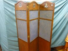 An oak three fold dressing screen with cloth covered central panels and simple fretted top
