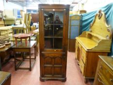 A good quality reproduction oak one piece corner cupboard with six panel glass top and four