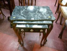 A set of three faux marble and gilt wood side tables, decorated with Limoges style porcelain