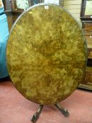 A late Victorian walnut oval topped breakfast table on a four column pedestal base with carved