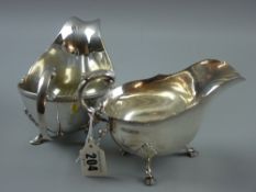 A silver sauce boat having a scrolled and feathered handle on three shell and hoof supports, 7