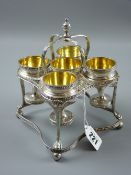 A silver five cup eggstand, the square shaped stand having a double tier with dart decoration, the