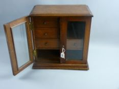 An oak two door smoker's cabinet with bevelled glass, the interior with a two section and three