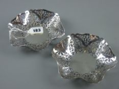 A pair of hexagonal silver bon bon dishes, the wide borders extensively pierced and decorated, 6