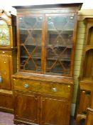 A Georgian mahogany bookcase cupboard, a moulded crown over twin astragal glazed eleven pane doors
