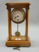 A satinwood architectural style mantel clock, four pillar temple style design on a stepped base with