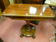 A Victorian mahogany foldover card table with carved front lower frieze on a tapering cylinder