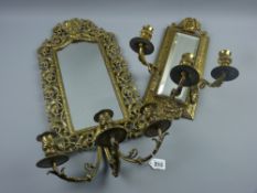 A 20th Century cast and pierced brass wall mirror with Bacchus mask top decoration and three