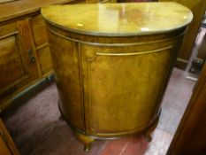 A 20th Century walnut demi-lune single door side cabinet with two interior drawers on short Queen