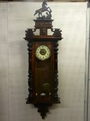 A 19th Century walnut encased Vienna style pendulum driven wall clock with numbered dial, the