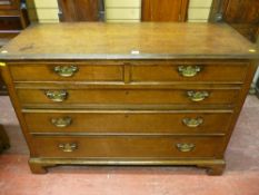 An early 19th Century oak chest of two short over three long drawers, cock beaded and crossbanded