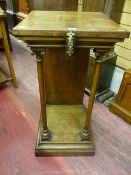 An oak side stand with square top and brass ring embellishment above a chamfered frieze supported by