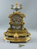 A French gilt metal clock with painted porcelain dial and inset lower panel, the top surmounted with
