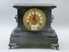 A cast metal gilt highlighted mantel clock with lion mask ring handles and lion's paw metal corner