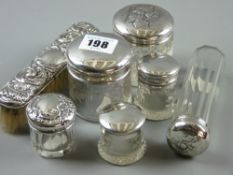 A parcel of seven silver topped/banded glass dressing table containers and a silver topped oblong