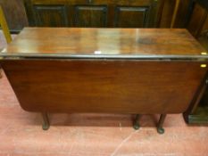 An antique mahogany twin flap gate leg table on turned legs and cross stretchers with pad foot feet,