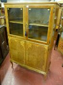 A 20th Century French style walnut cabinet of two glazed doors over two inlaid bottom doors with
