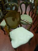 A pair of Edwardian walnut library chairs with heavily carved curved backs and centre shaped