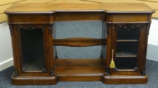 A rosewood break-front credenza having two single door glazed cabinets flanking a mirrored open-