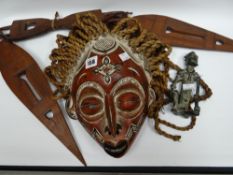 A painted native carved mask with wicker-work 'hair'; together with a carved three-piece spear and a
