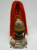 A half-size Life Guards helmet with plumage on white metal hinged plinth