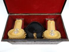 A Victorian naval officer's bicorn hat and epaulettes cased in a quality Gieves Japanned metal