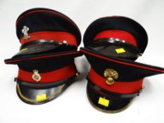 Four army peaked caps with red bands, three with insignia