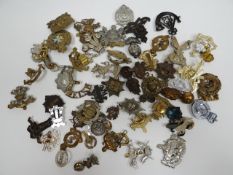 A quantity of assorted regimental cap badges, shoulder titles and collar badges