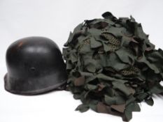 A modern British camouflage helmet together with a German helmet with leather liner