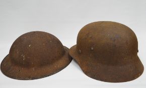 WWII German helmet, together a British helmet, both in relic condition