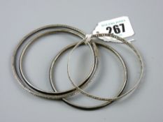 Two white metal bangles and two black enamel and white metal bangles
