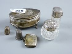 An oval silver ring box on four supports, the hinged lid having raised cherubic decoration and