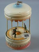 A vintage tinplate clockwork musical carousel with tinplate figures (one missing), 24 cms high