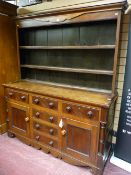 A 19th Century oak and mahogany dresser with a three shelf rack over a base with mahogany edge