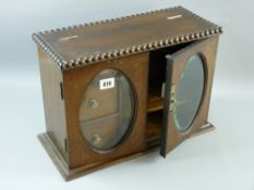 A 1930's oak smoker's cabinet, the hinged top with bead edged decoration above twin  doors with oval