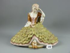 A fine later Royal Dux figurine of a young lady in flowing dress seated on a couch reading a book