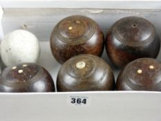 A group of five wooden carpet bowls and a pottery jack